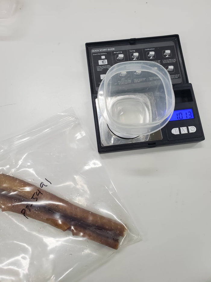 Rinsate from the first dog chew sample being transferred into a labeled vial